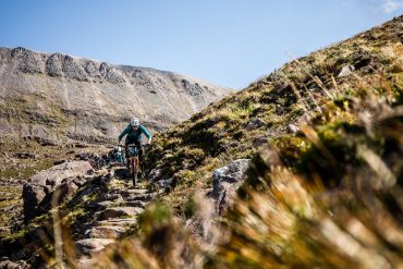 Mountain biker rides a technical trail on a trip with H+I Adventures