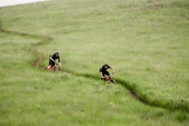 Two mean ride Specialized mountain bikes on grassy singletrack in South Africa