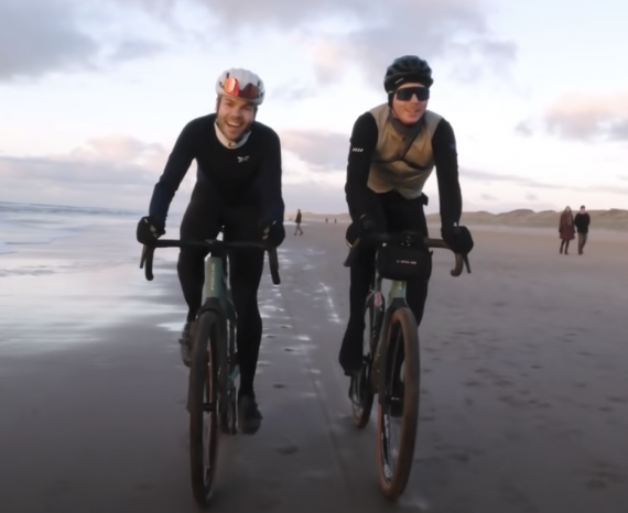 Two cyclists ride gravel bikes on the beach in the Netherlands