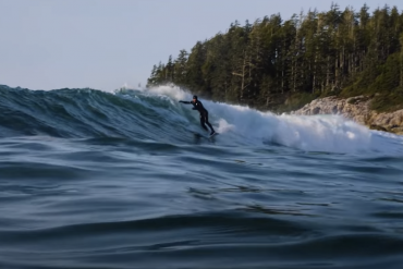 Surfer rides a wave in the cold water off Vancouver Island