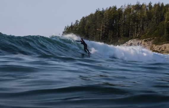 Surfer rides a wave in the cold water off Vancouver Island