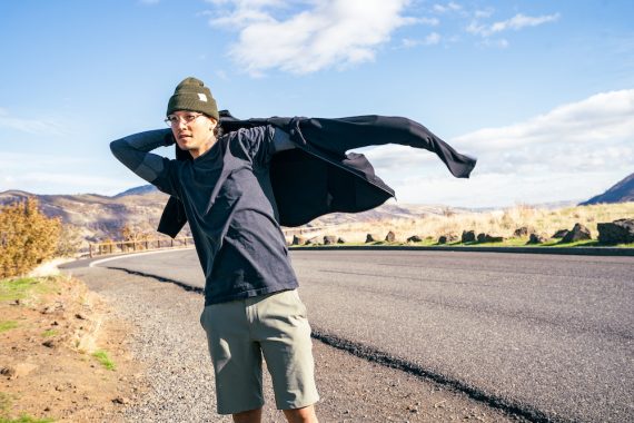 Man puts on his Chrome Cobra 3.0 performance hoodie on the side of the road