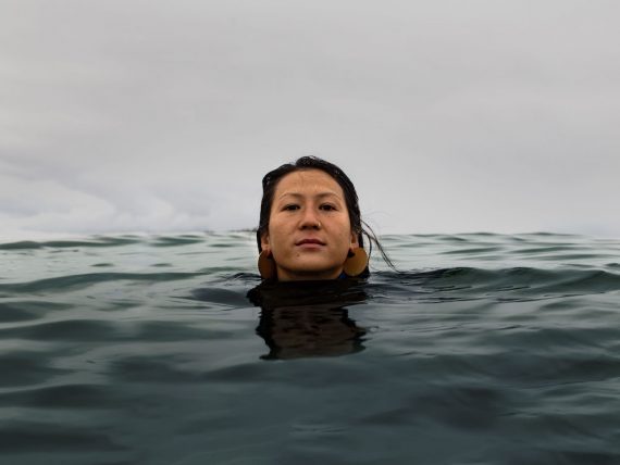 A girl treading water in the ocean with her head above the surface