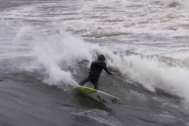 Man surfing in cold water off Minnesota's northern coast of Lake Superior