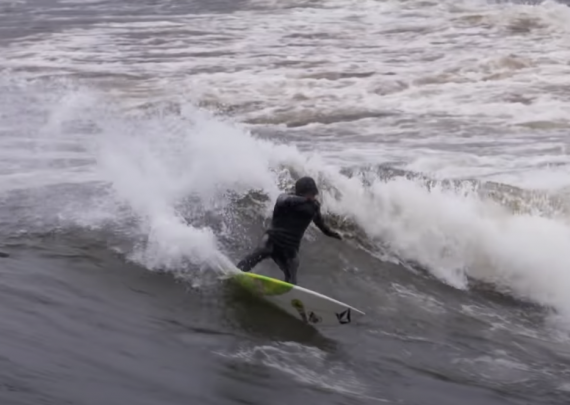 Man surfing in cold water off Minnesota's northern coast of Lake Superior