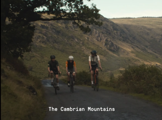 Three ladies riding road bikes up a mountain road in Wales