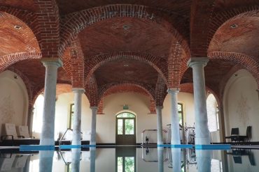 Historic indoor pool in Europe with red brick and arched ceilings