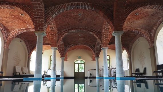 Historic indoor pool in Europe with red brick and arched ceilings