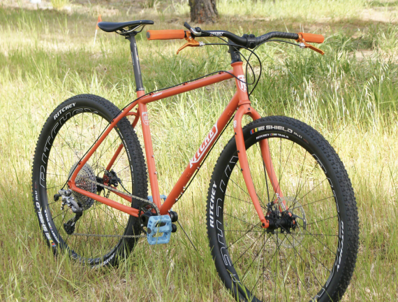 Ritchey Ascent gravel bike in orange with blue pedals