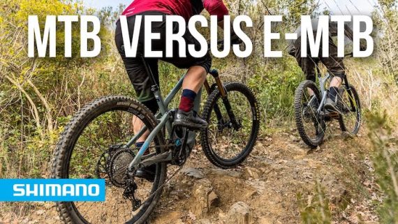 Two men riding electric mountain bikes on a rocky dirt trail