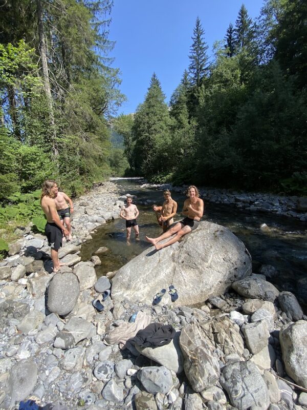 Cyclists siting in a river's edge in Morzine, France after a tough ride.