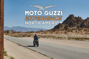 A man riding his Moto Guzzi through the US desert.