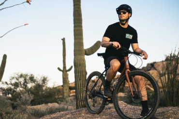 A young male cyclist sitting on his State 4130 All-Road Flat Bar gravel bike in the Arizona desert.
