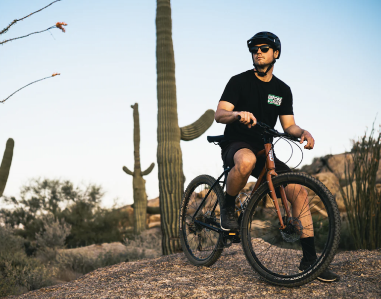 A young male cyclist sitting on his State 4130 All-Road Flat Bar gravel bike in the Arizona desert.