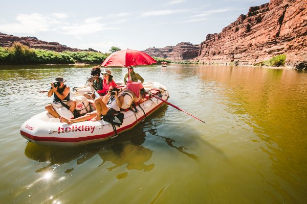 A group relaxes on a raft in Cataract Canyon.
